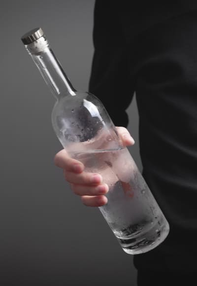 Мужчина держит в руках бутылку